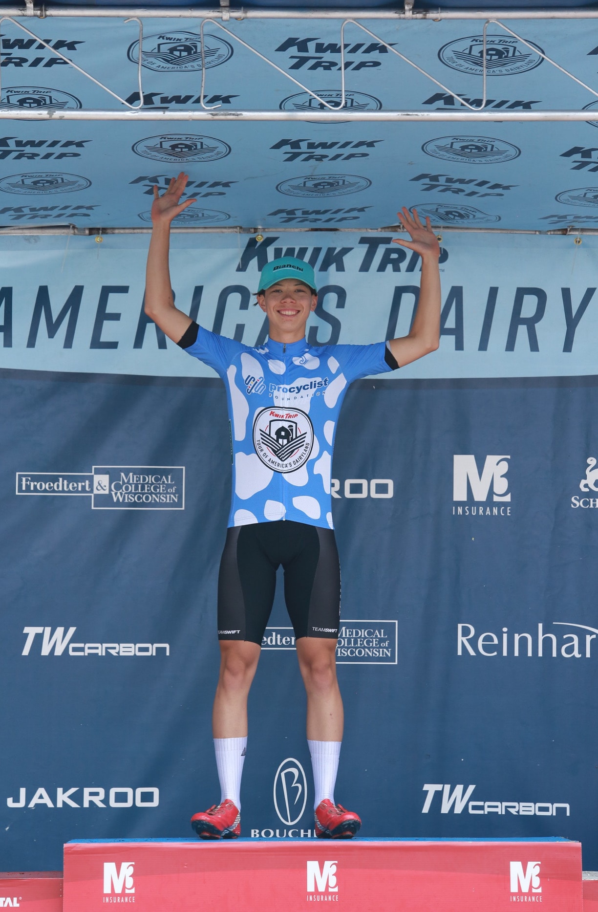 Cyclist celebrating on the podium at Kwik Trip Tour of America's Dairyland